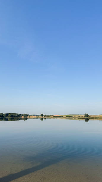 istock Serene landscape with tranquil lake and clear sky reflecting water surrounded by greenery horizon for peaceful outdoor experience 2213543455