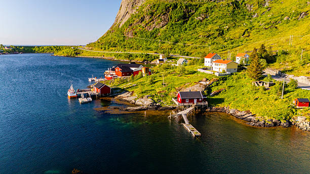 istock Charming coastal village in Norway surrounded by lush greenery and serene waters during golden hour 2213550244