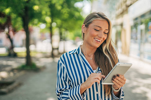 istock Smiling businesswoman using digital tablet in urban setting 2213551202