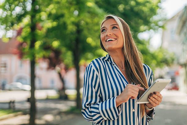 istock Smiling businesswoman using digital tablet in urban setting 2213551263