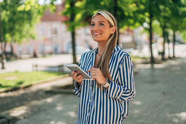 istock Young professional woman using digital tablet in urban park 2213551353