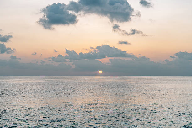 Stunning sunset casting vibrant hues over the Indian Ocean in the Maldives, creating a breathtaking golden hour landscape