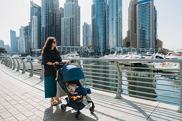 istock Mother pushing stroller with sleeping baby in Dubai Marina 2213552713