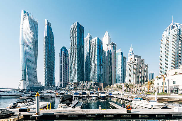 Modern cityscape of Dubai Marina with its iconic skyscrapers and a harbor full of yachts, reflecting the city's opulence and architectural prowess