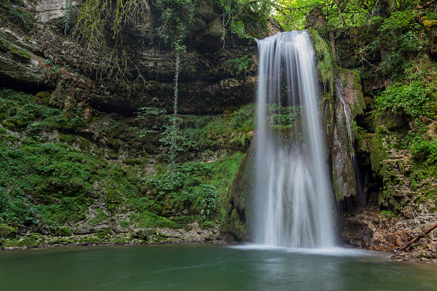istock A waterfall is flowing into a small pool of water 2213553061