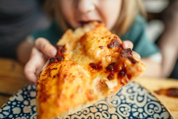 istock Child eating pizza in a cafe 2213553428