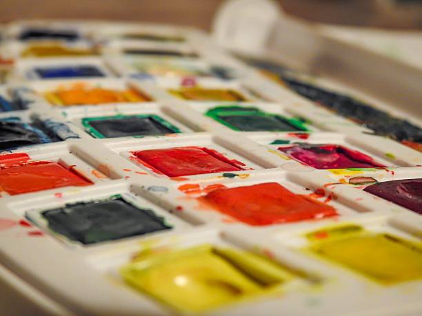 Close-up of a watercolor paint palette with vibrant colors in a creative setting.