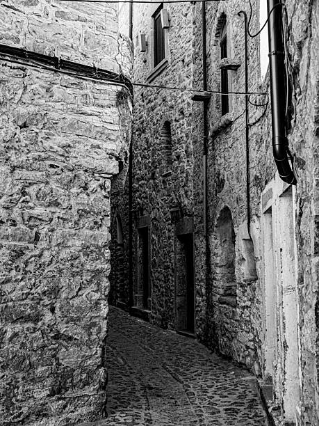 istock Narrow cobblestone alleyway between ancient stone buildings. 2213554802