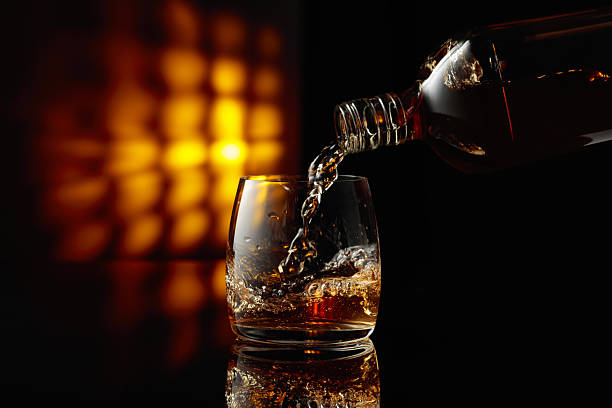 istock Pouring whiskey from a bottle into a glass. 2213554913