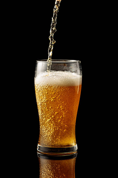istock Pouring beer into a glass on a black reflective background. 2213554953