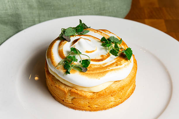 Lemon tart with toasted meringue and herbs.