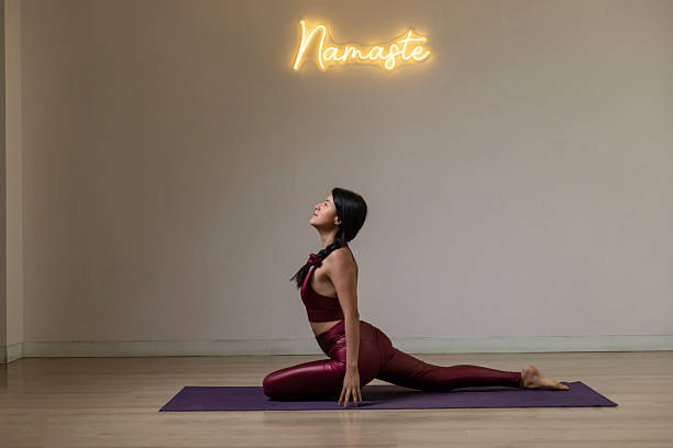 Young woman practicing yoga in a studio with namaste sign