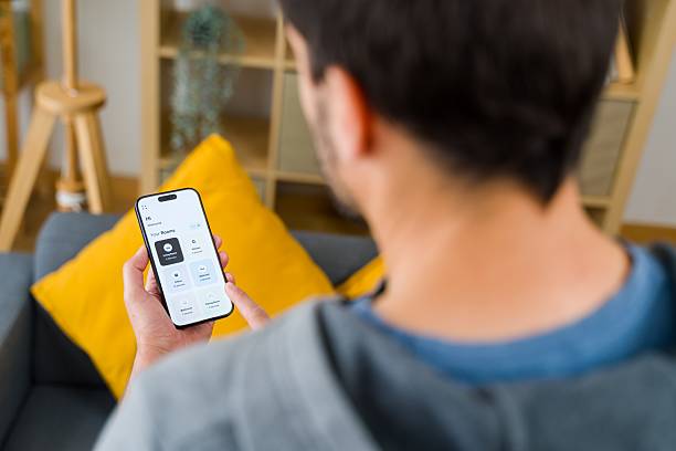 istock Young Adult Using Smartphone for Smart Home Control 2213562368