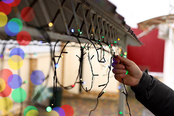 istock Man decorating house with Christmas lights outdoors, closeup 2213566903