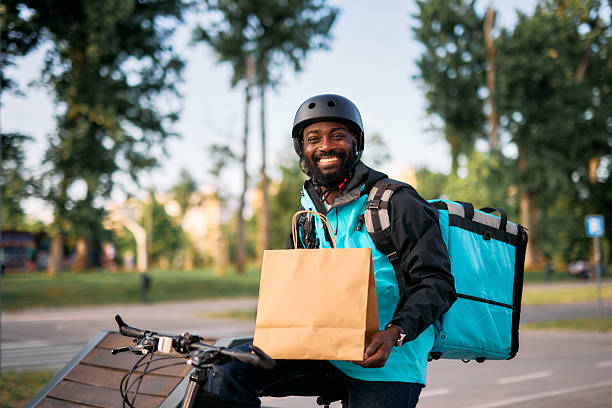 istock Smiling Courier Delivering Food on Bicycle 2213567483