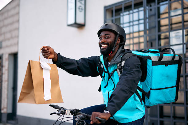 istock Smiling Courier Delivering Food on Bicycle 2213567560