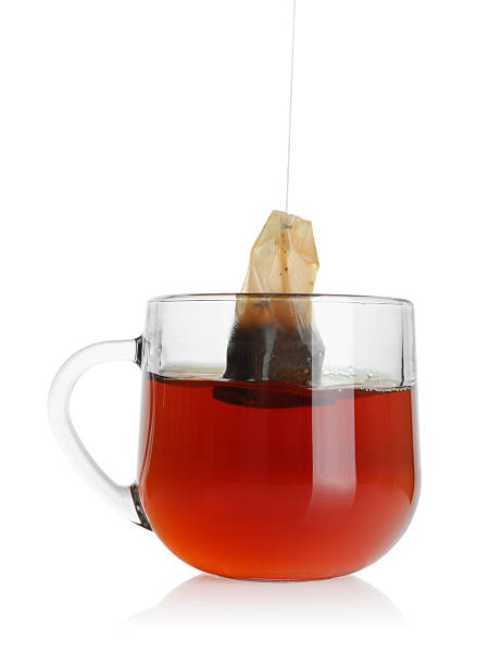 istock Putting tea bag into glass cup on white background 2213568003