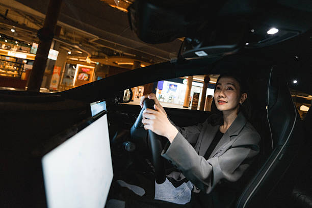 istock A woman using the EV car's app while driving home 2213569458