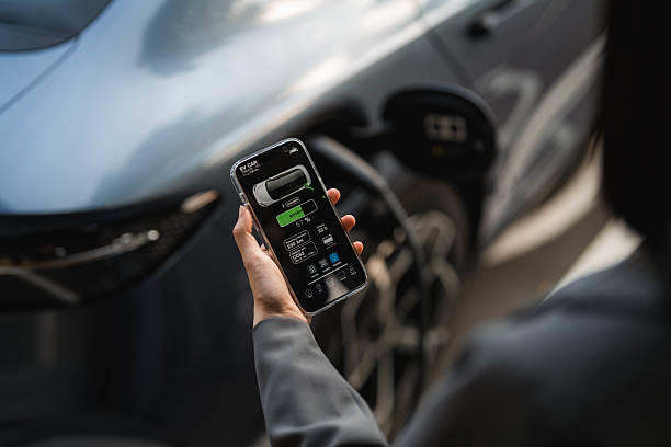 istock A woman standing at the EV charging station, using her smartphone while waiting for her electric vehicle to finish charging 2213569621