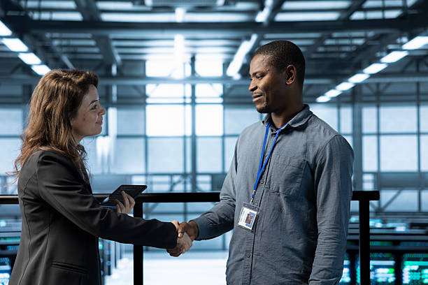 istock IT specialist doing handshake with supervisor inspecting server farm gear 2213569710