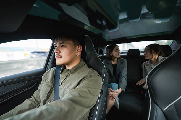 Two passengers talking in the backseat as the driver carefully navigates the road, making their way toward their destination