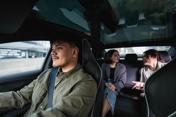 istock Two passengers talking in the backseat as the driver carefully navigates the road, making their way toward their destination 2213569849