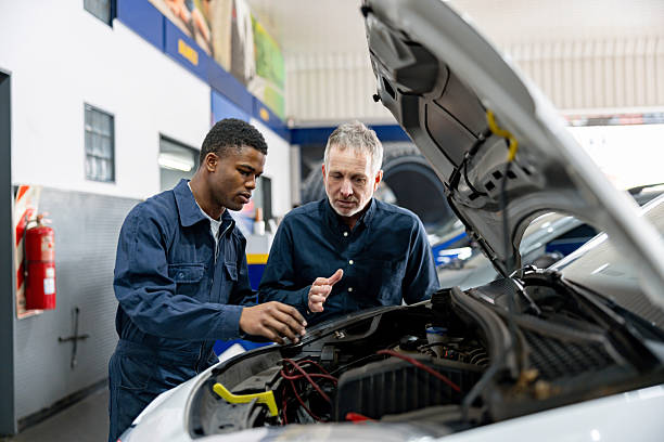 istock Senior engineer talking to a mechanic at a car garage 2213571438