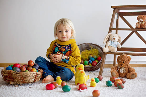 Playful caucasian girl decorating for Easter. She is in the domestic room, collecting eggs.