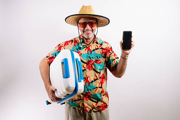 istock Traveler showing phone and holding blue suitcase 2213574429