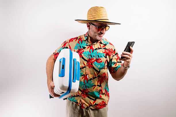 istock Traveler showing phone and holding blue suitcase 2213574433