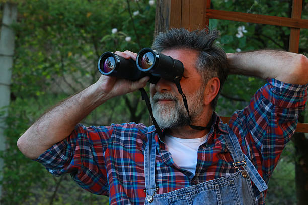 istock Senior silver man looking bird in nature 2213574728