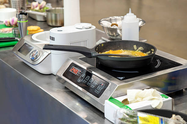 Saucepan cooking on induction stove in professional kitchen close-up