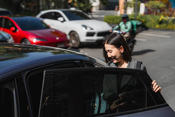 istock Businesswoman entering EV car shared with her colleagues, ready for the commute to work 2213575169
