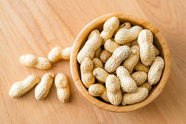 istock Bowl filled with organic peanuts shot from above on wood table 2213575402