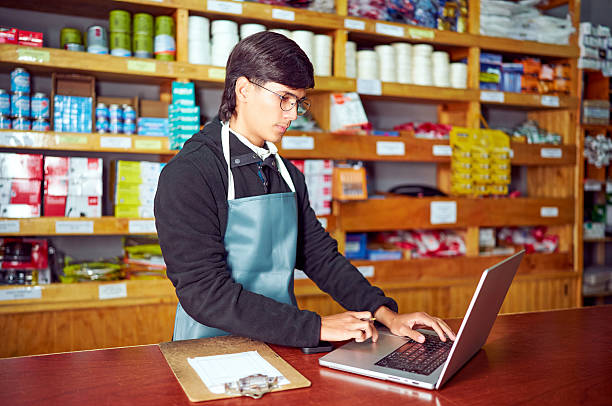 istock Shopkeeper managing inventory using laptop in hardware store 2213578509