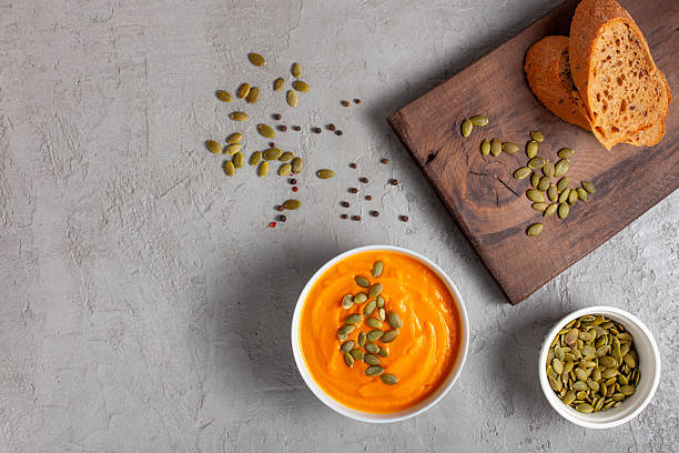 istock Pumpkin Soup with Seeds and Rustic Bread. Flatlay, Copy space 2213579455