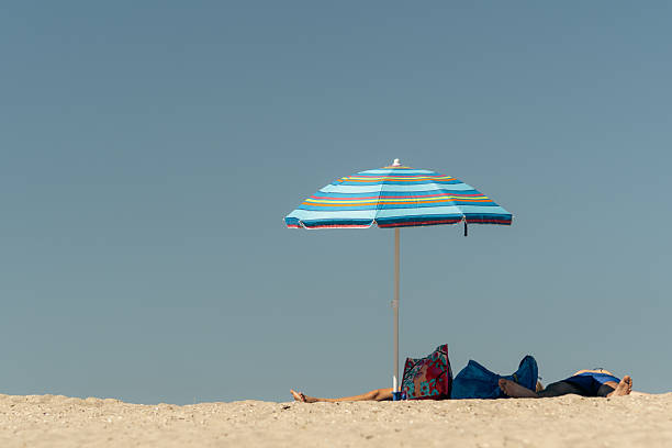 summer scene with blue striped parasol on the beach
