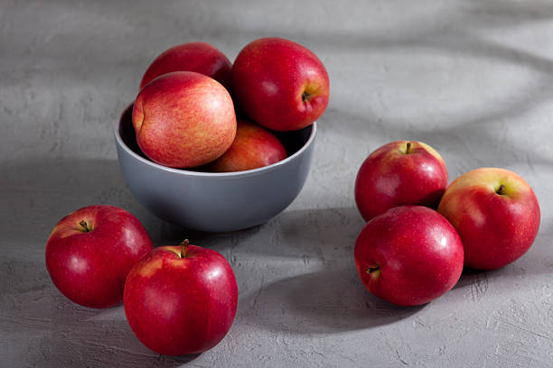 istock Fresh red apples in a bowl on gray surface 2213581341