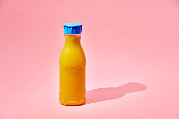 istock Orange Juice in Recycled PET Plastic Bottle on Vibrant Background 2213584193
