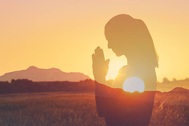 istock Woman praying in the warm sun. 2213584684