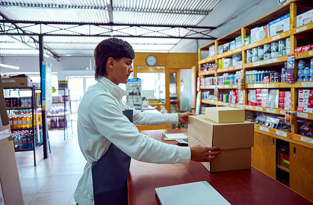 istock Young shopkeeper working at counter with boxes in hardware store 2213585839