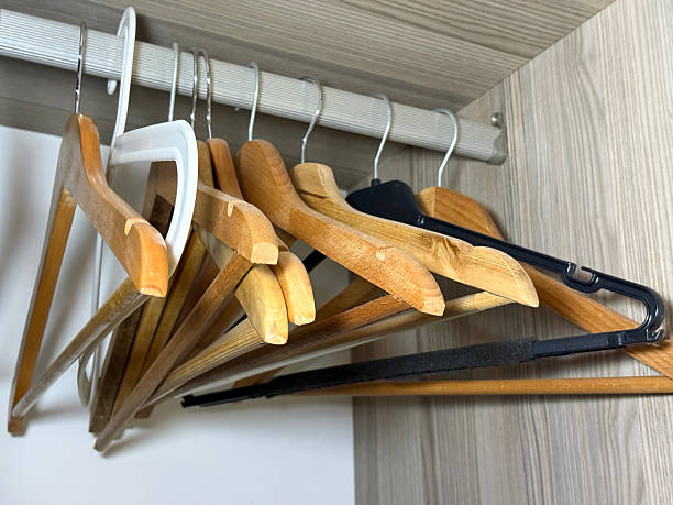 Plastic and wooden coathangers hanging in a wardrobe or clothes rack