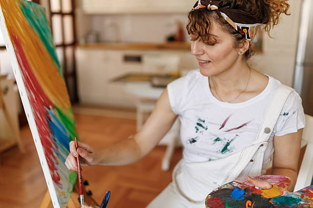 istock Beautiful female painter working at home 2213590099