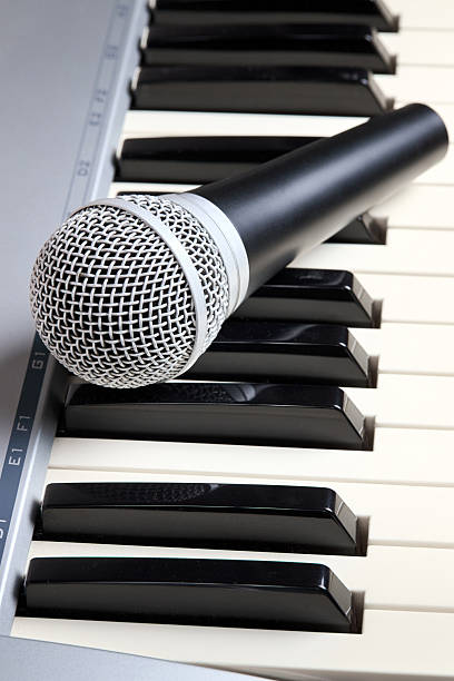 istock Microphone on midi piano keyboard keys. Recording studio concept. Vertical shot 2213590341