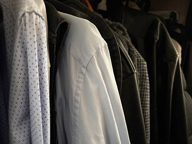 Group of menswear hanging on coat hangers in clothes rack