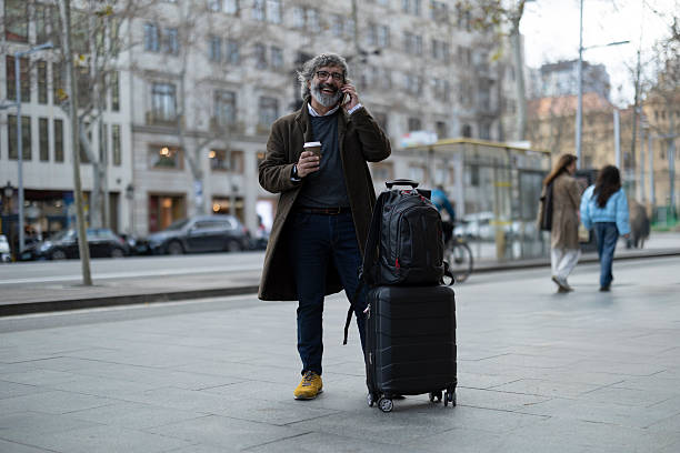 istock Senior business traveler talking on phone while holding coffee 2213590515