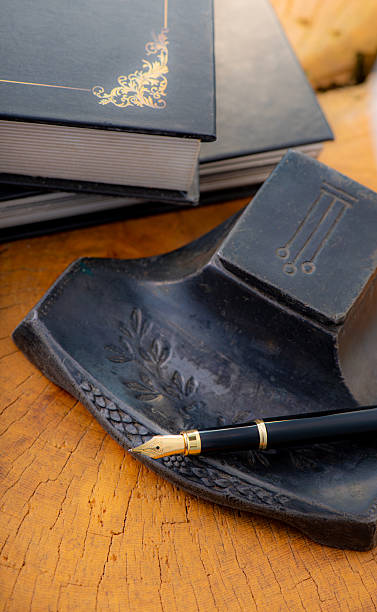 istock Fountain pen, a beautiful fountain pen with books and other objects on a rustic wooden surface, selective focus. 2213592385