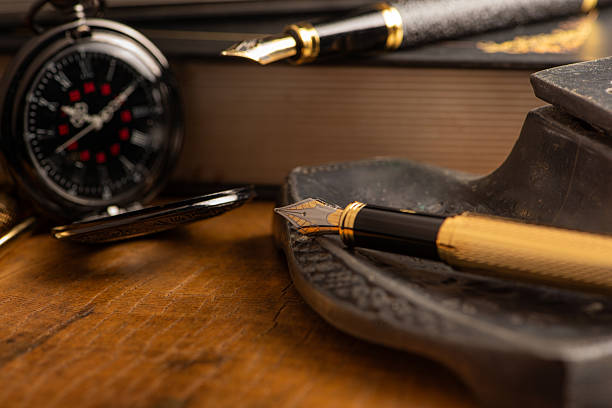 istock Fountain pen, two beautiful fountain pens with books on a rustic wooden surface, selective focus. 2213592443