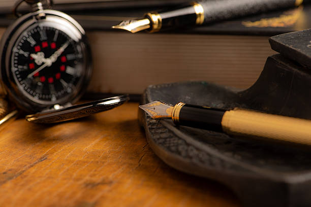 istock Fountain pen, two beautiful fountain pens with books on a rustic wooden surface, selective focus. 2213592446