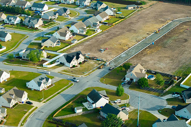 istock New Development Neighborhood - House Under Construction - Wide Shot - Empty Lots 2213592590